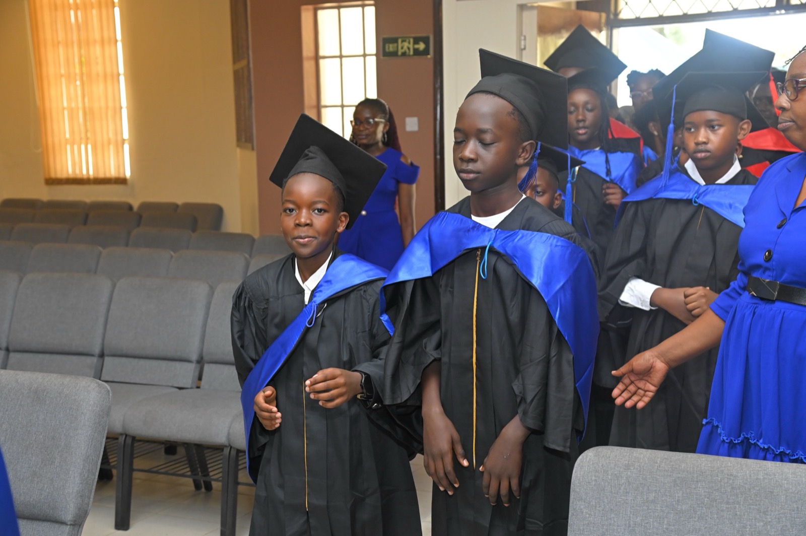 Grade 9 graduates in black gowns walking in