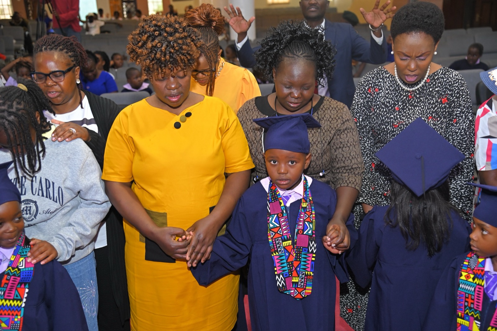 Parents praying over PP2 graduates at Kings International Academy