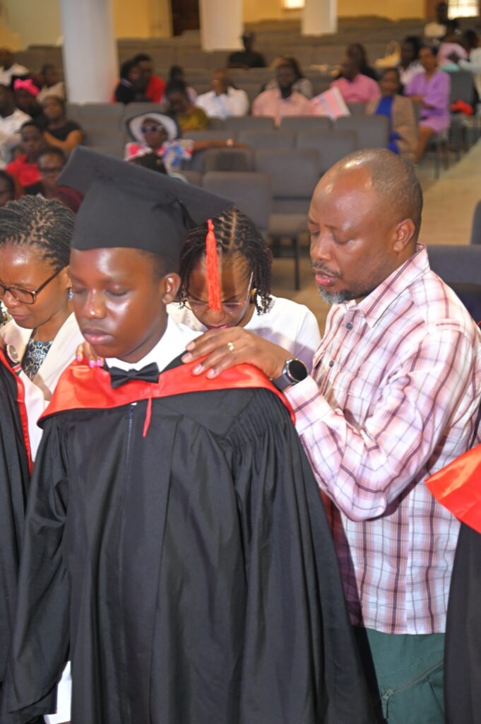 A parent placing the hood on a graduate