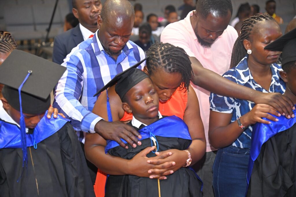 A parent hugging a graduate during the robing