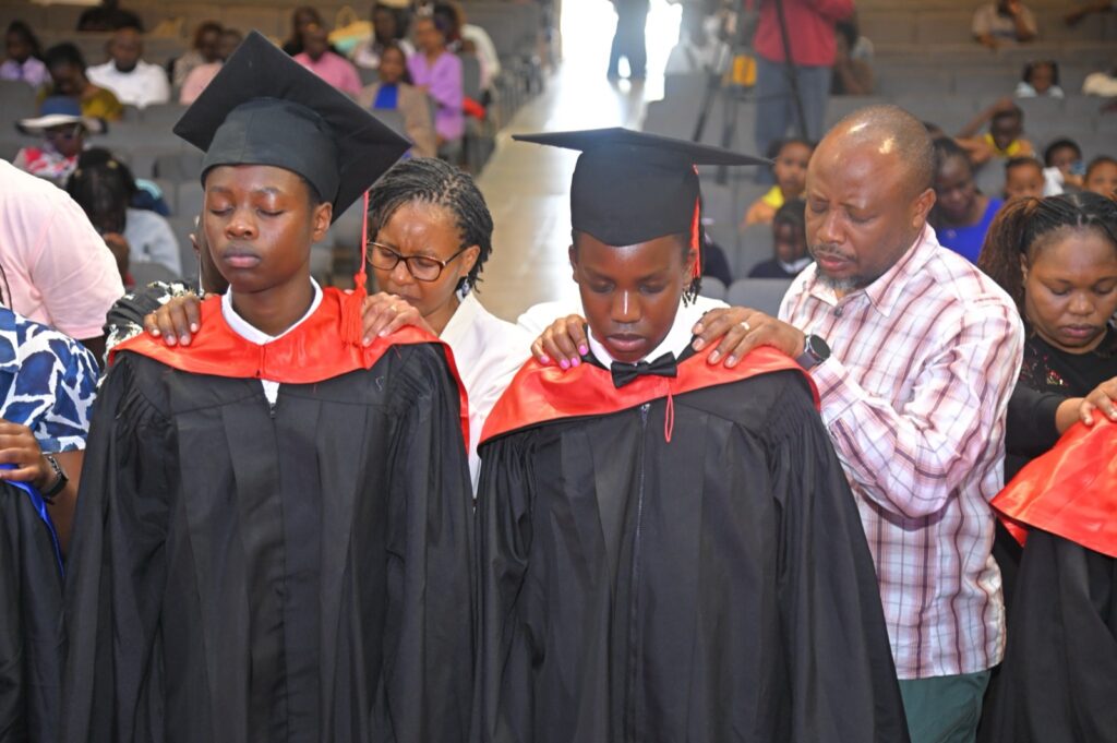 Graduates being robed by their parents